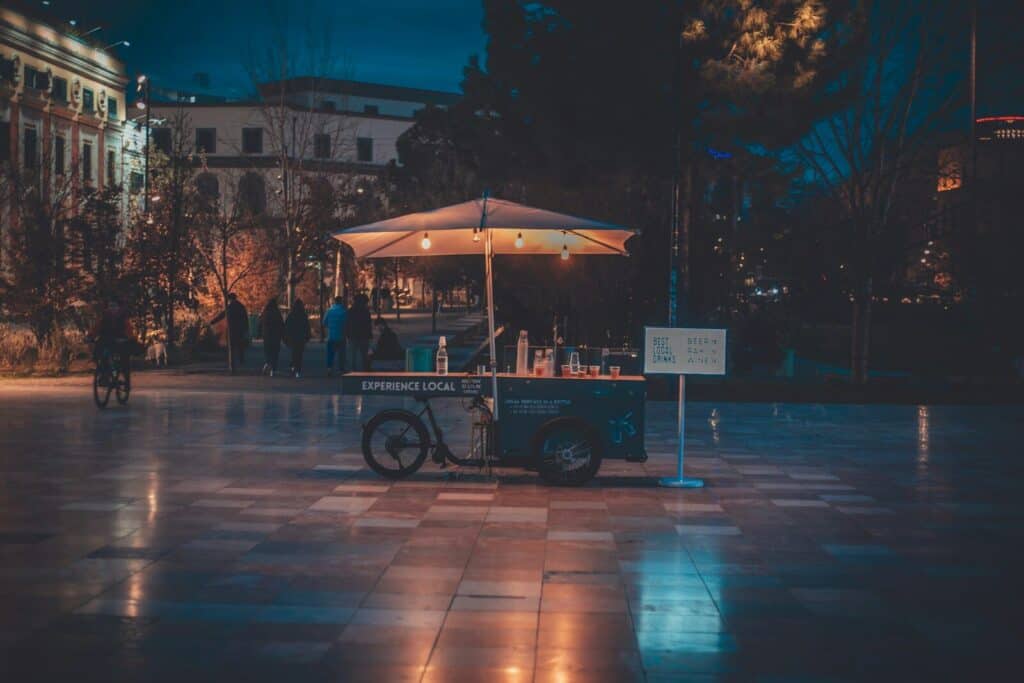 A food cart stands illuminated at night